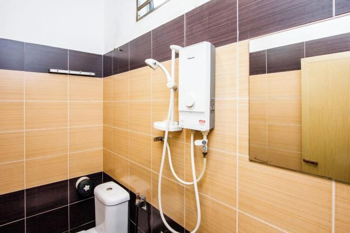 A bathroom with a shower unit, a toilet, and a hand dryer.