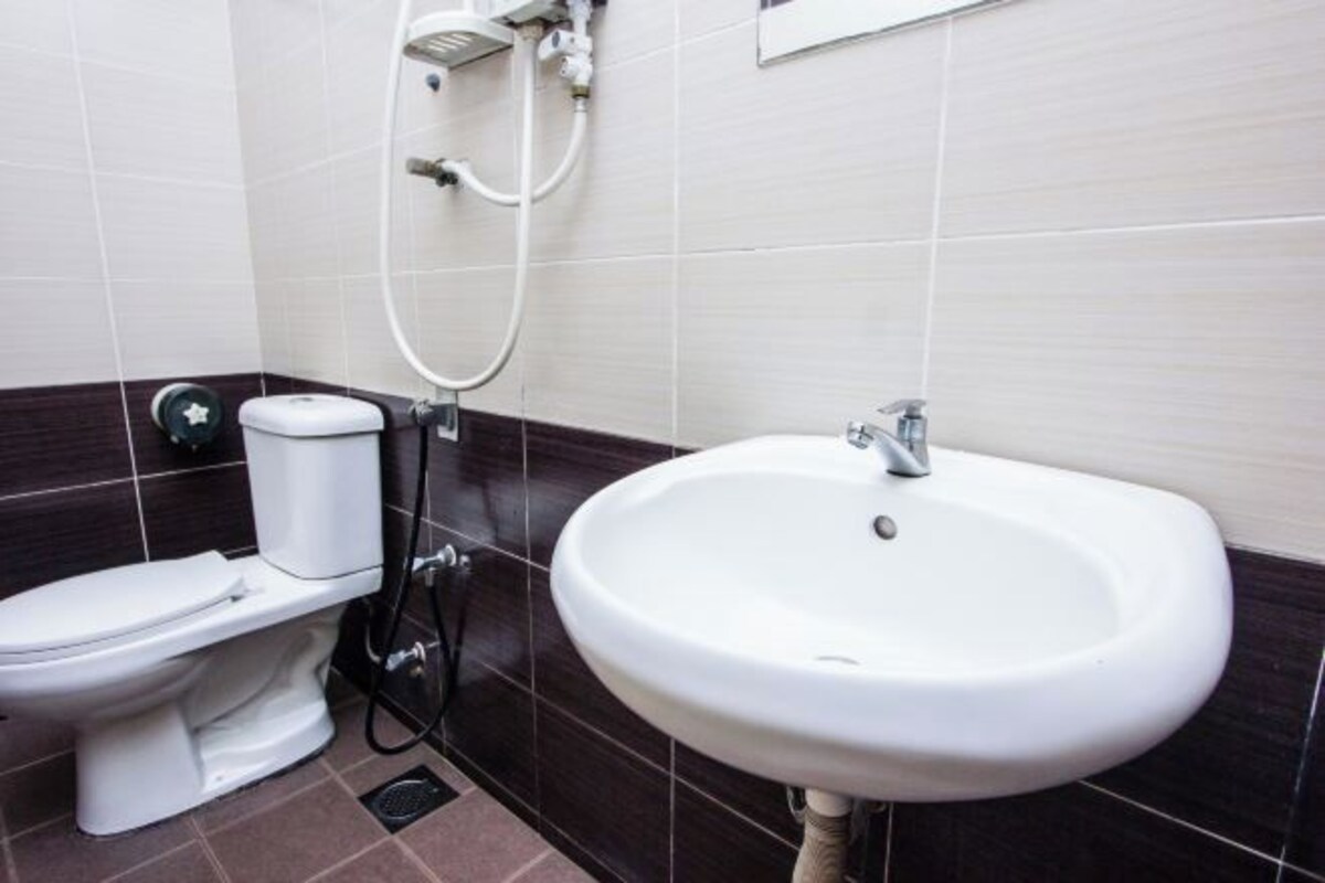 Une salle de bain comprenant des toilettes, un bidet et un lavabo.