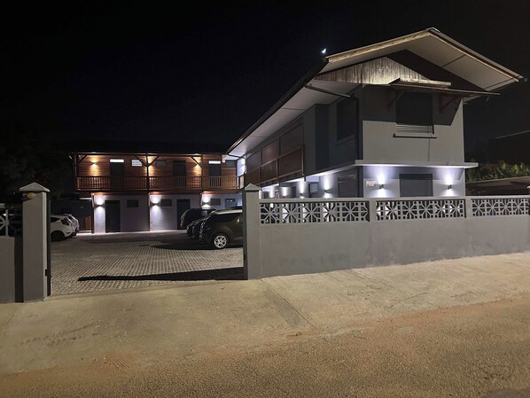 A modern two-story house with a covered driveway and a gated entrance.