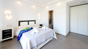 A modern bedroom with a bed, bedside tables, a wardrobe, and a built-in bench. - Casa Eva in Nerja With 3 Bedrooms and 3 Bathrooms (Nerja)