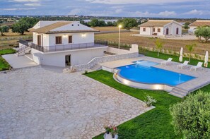 A modern villa with a swimming pool, stone patio, and a view of the countryside. - Villetta Bianca in Scicli (Scicli)