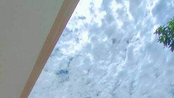 Un edificio a più piani con un tetto verde, una zona esterna coperta e un prato curato.