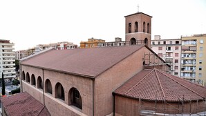 A building with a red-tiled roof, a brick facade, and a bell tower. - Emerenziana Lovely Apartment (Rome)