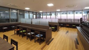 Een moderne kantoorruimte met open werkplekken, houten bureaus en stoelen.