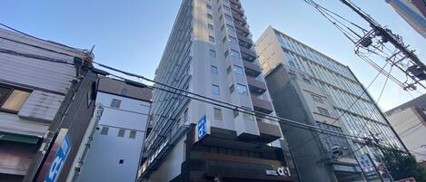 A multi-story hotel with a modern facade, multiple balconies, and a visible entrance.