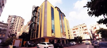 Un edificio de varios pisos con fachada amarilla y ventanas grandes.