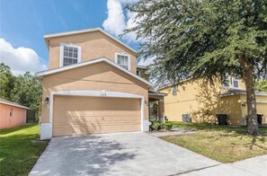 A two-story house with a beige exterior, a garage number 339, and a tree in the front yard. - Luxurious 4-bedroom Apartment With Private Pool in Davenport (Davenport)