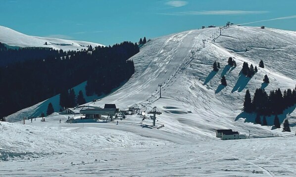 A snow-covered ski slope with ski lifts, a small building, and a forested area. - Hotel Gaarten Benessere&Spa by Kleos Group Collection (Gallio)