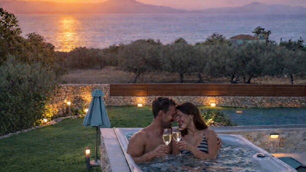 A couple in a hot tub with a sunset view over the sea. - Kritiki Spilia - Home & Spa (Prines)