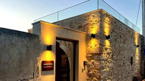 A stone building with a sign reading "KPHIHAIA" and a door leading inside. - Kritiki Spilia - Home & Spa (Prines)