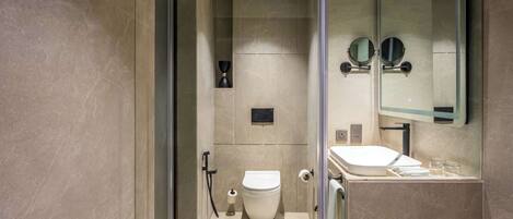 Un baño moderno con inodoro, lavabo y espejo.