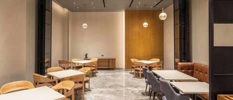 A modern interior with tables and chairs arranged for dining.