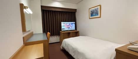Una habitación de hotel con cama, escritorio, silla, televisor y un cuadro en la pared.