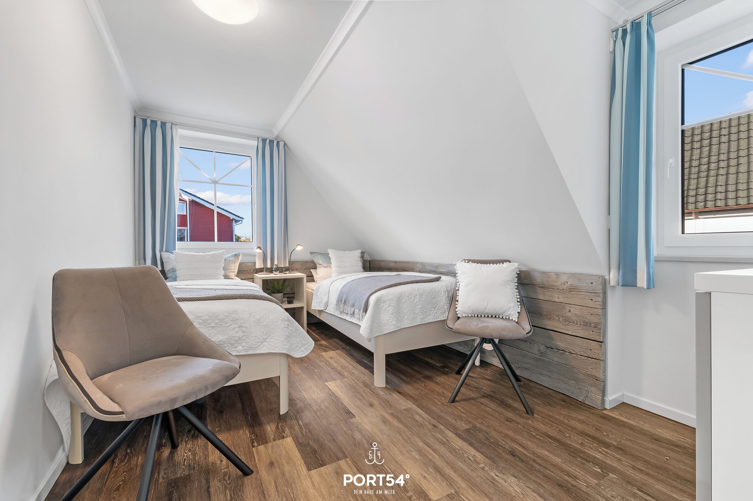 A modern, well-lit room with a bed, a chair, and a small table.