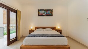 A bedroom with a wooden bed, two bedside lamps, and a large window with curtains. - Hotel Anyar Teges (Ubud)