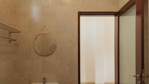 A bathroom with a sink, mirror, and glass shower door. - Hotel Anyar Teges (Ubud)