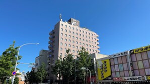 A multi-story hotel with a prominent 'HOTEL' sign on the facade, several balconies, and a clear blue sky in the background. - Hotel Alpha-One Yonago (Yonago)