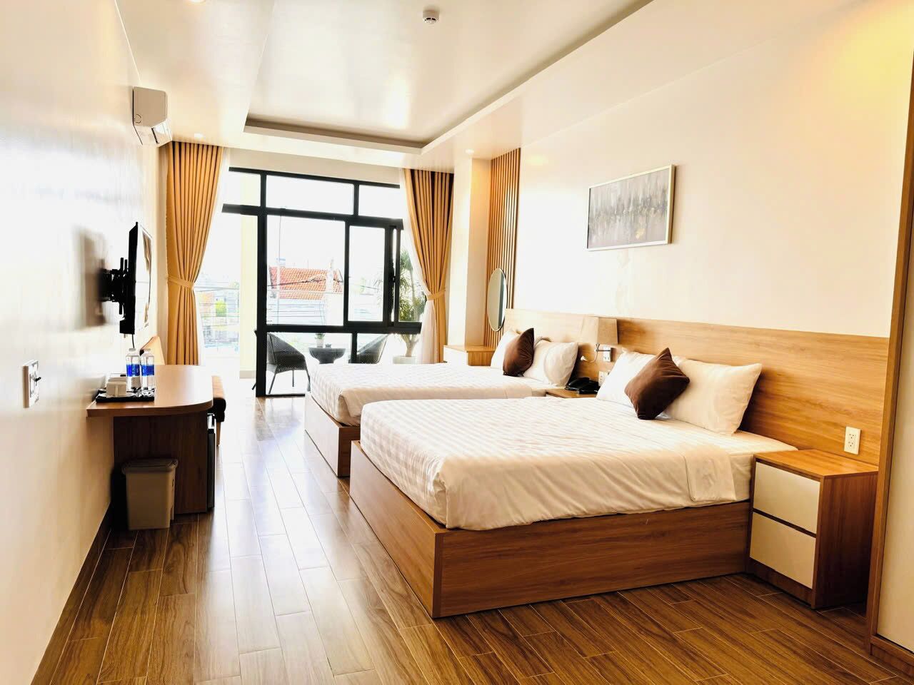 A hotel room with a large bed, a desk, and a view of the outside.
