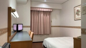 A hotel room with a desk, two monitors, a bed, a window with curtains, and a framed picture on the wall. - Hotel Alpha-One Onomichi (Onomichi)