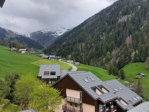 A rural mountain village with traditional wooden houses, a winding road, and a backdrop of snow-capped mountains. - Cozy duplex for 5/6 people in Arêches-Beaufort, ski-in/ski-out (Arêches-Beaufort)