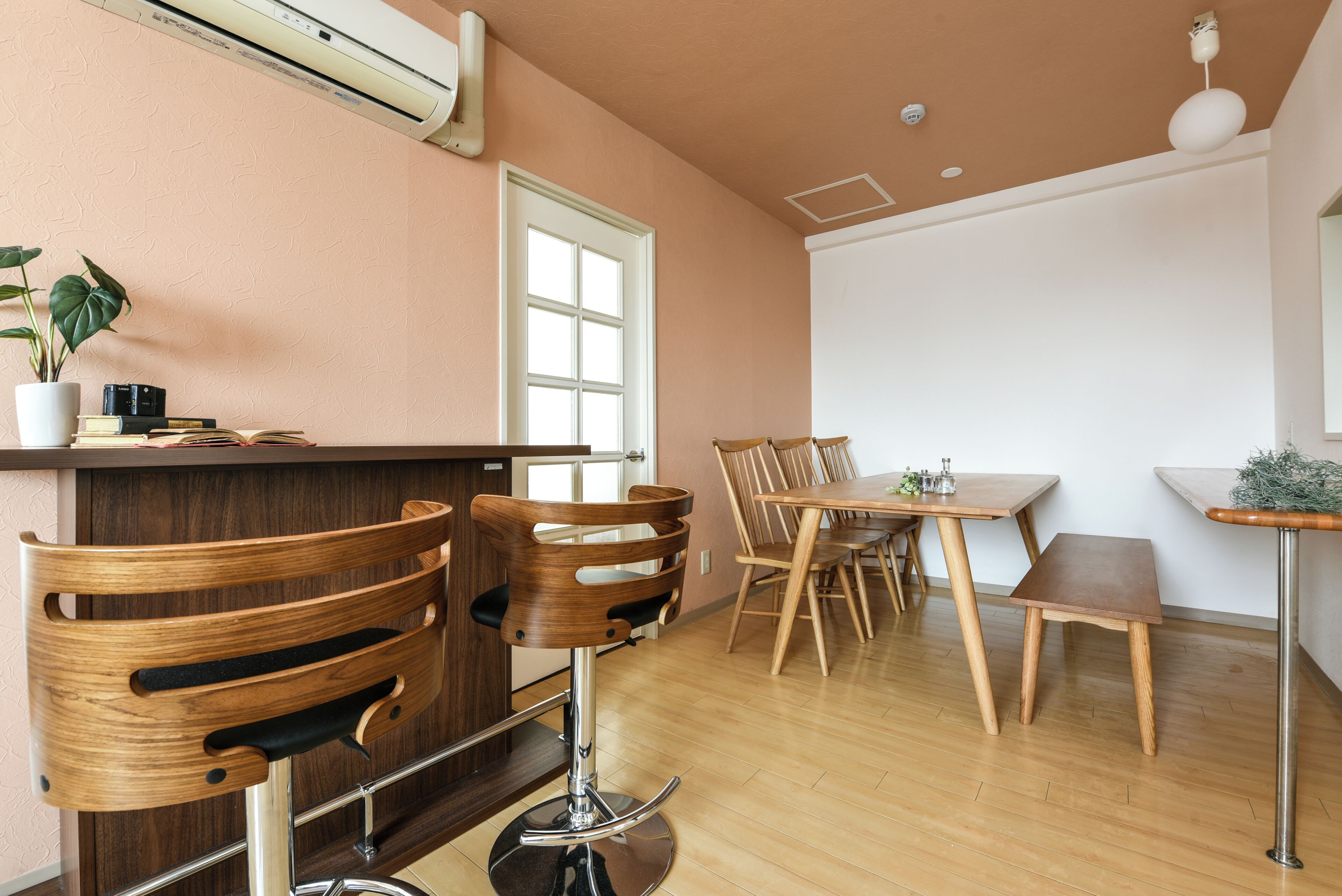 Un espace repas moderne, avec des meubles en bois, un comptoir de bar et une plante en pot.