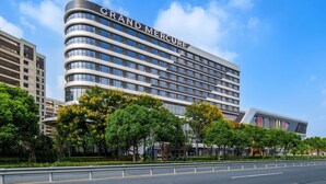 Un hotel moderno con una facciata curva e la scritta "GRAND MERCURE" ben visibile.