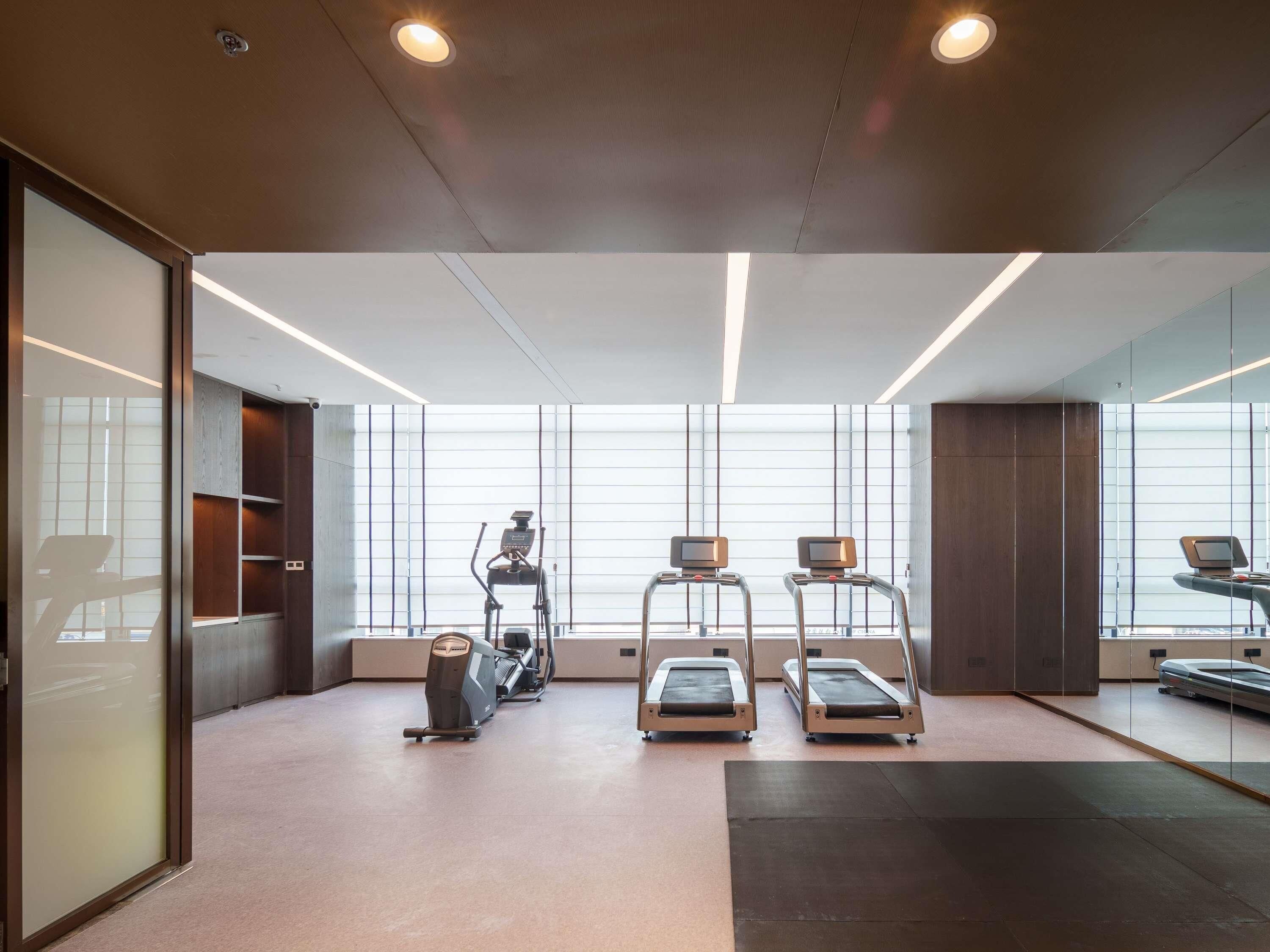 A modern gym with treadmills, an elliptical, and a stationary bike.