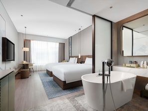A modern hotel room with a large bed, a separate sitting area, a bathtub, and a flat-screen TV. - Grand Mercure Changzhou Luoxi (Changzhou)