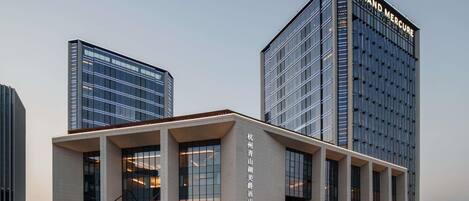 A modern hotel with two prominent buildings, one with a sign reading 'Grand Mercure.'
