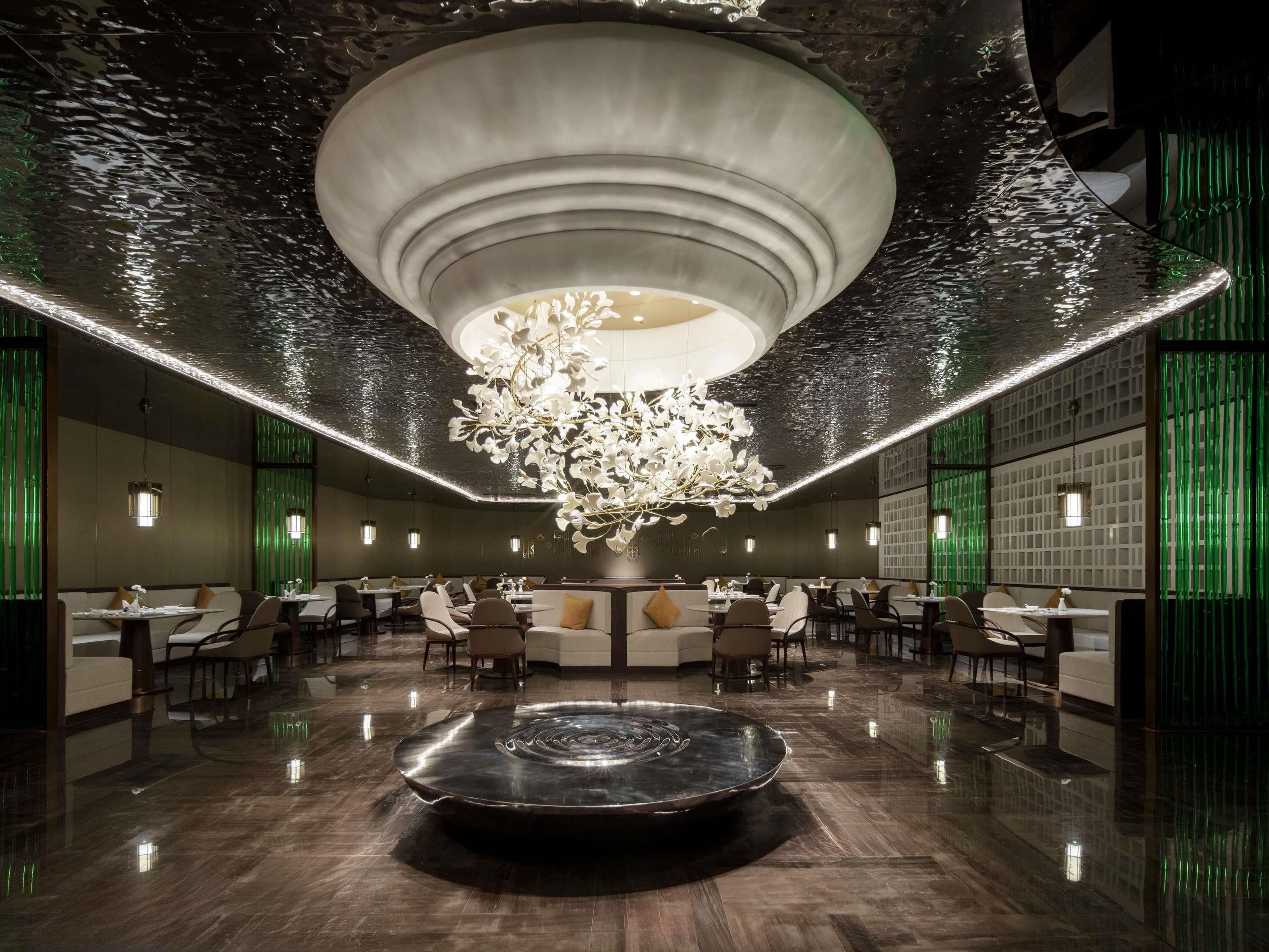 A modern interior with a central water feature, seating areas, and ambient lighting.