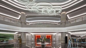 A modern lobby with a central reception desk, a chandelier, and a polished marble floor. - Grand Mercure Hangzhou Qingshan Lake (Hangzhou)