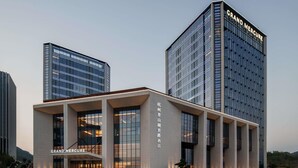 A modern hotel with two prominent buildings, one with a sign reading 'Grand Mercure.' - Grand Mercure Hangzhou Qingshan Lake (Hangzhou)