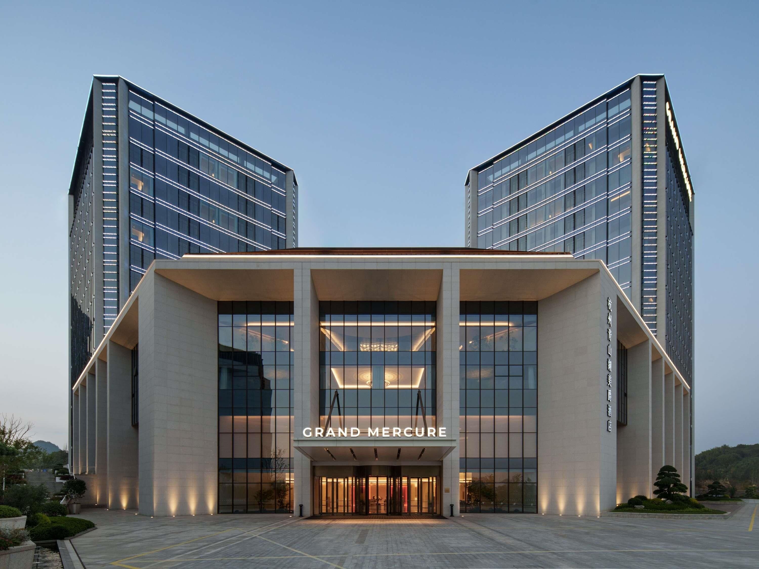 Un bâtiment moderne doté d’une entrée imposante, sur laquelle on peut lire l’inscription « GRAND MERCURE ».