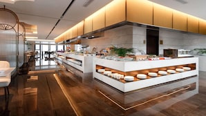 A modern kitchen with a central island, wooden cabinets, and a glass display case. - Grand Mercure Hangzhou Qingshan Lake (Hangzhou)