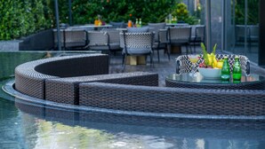 A poolside area with wicker furniture and a table with drinks and fruits. - Grand Mercure Shenzhen Guangming (Shenzhen)
