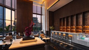 A modern lobby with a bar area, seating arrangements, and a large window offering a city view. - Grand Mercure Shenzhen Guangming (Shenzhen)