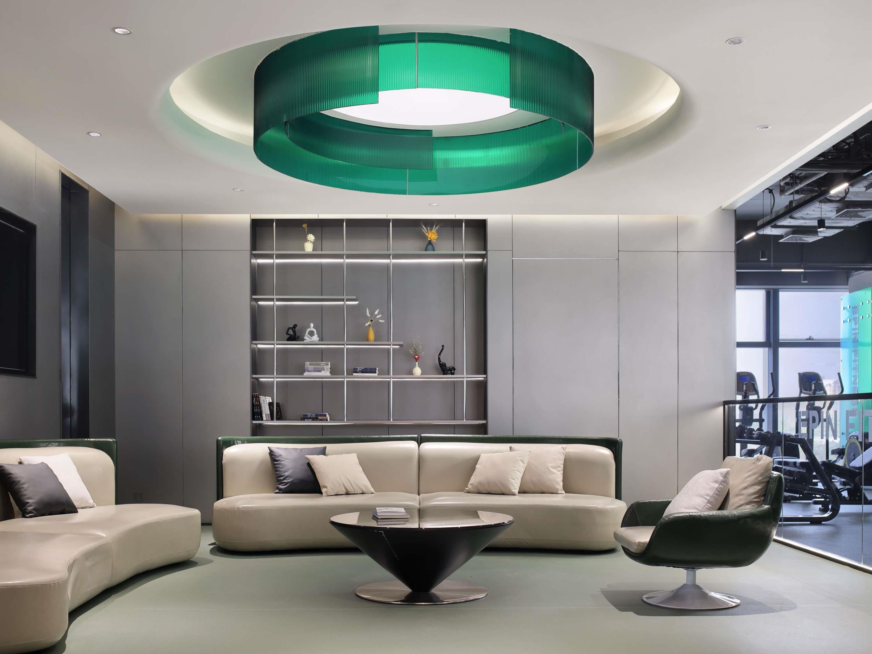 Um interior moderno com uma parede de destaque verde, um sofá, uma mesa de centro e uma estante.