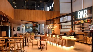 Moderni baarialue, jossa on puuhuonekaluja ja kyltti, jossa lukee ”BAR”.