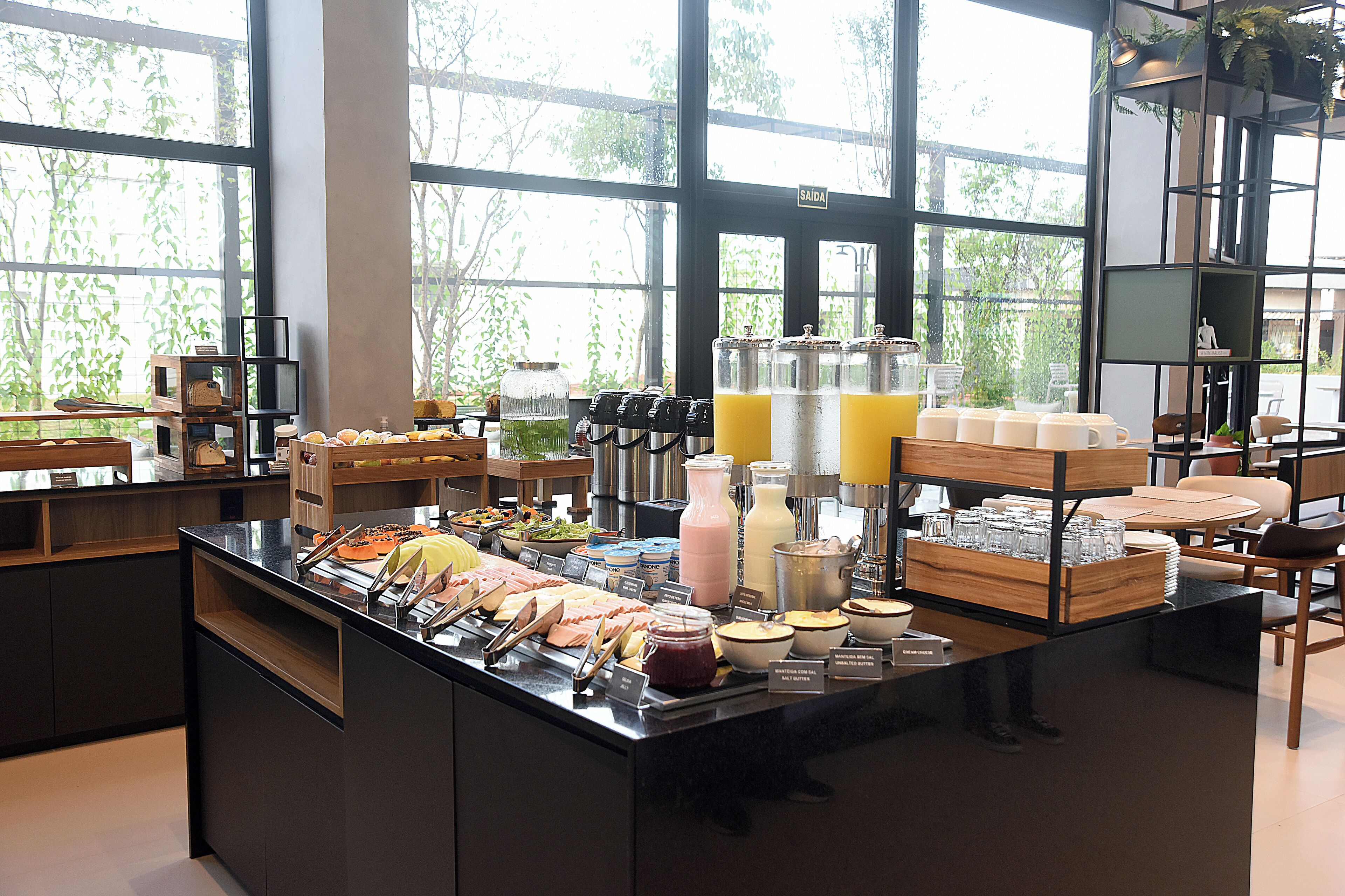 A buffet area with various food and drink options, a coffee station, and a seating area with tables and chairs.