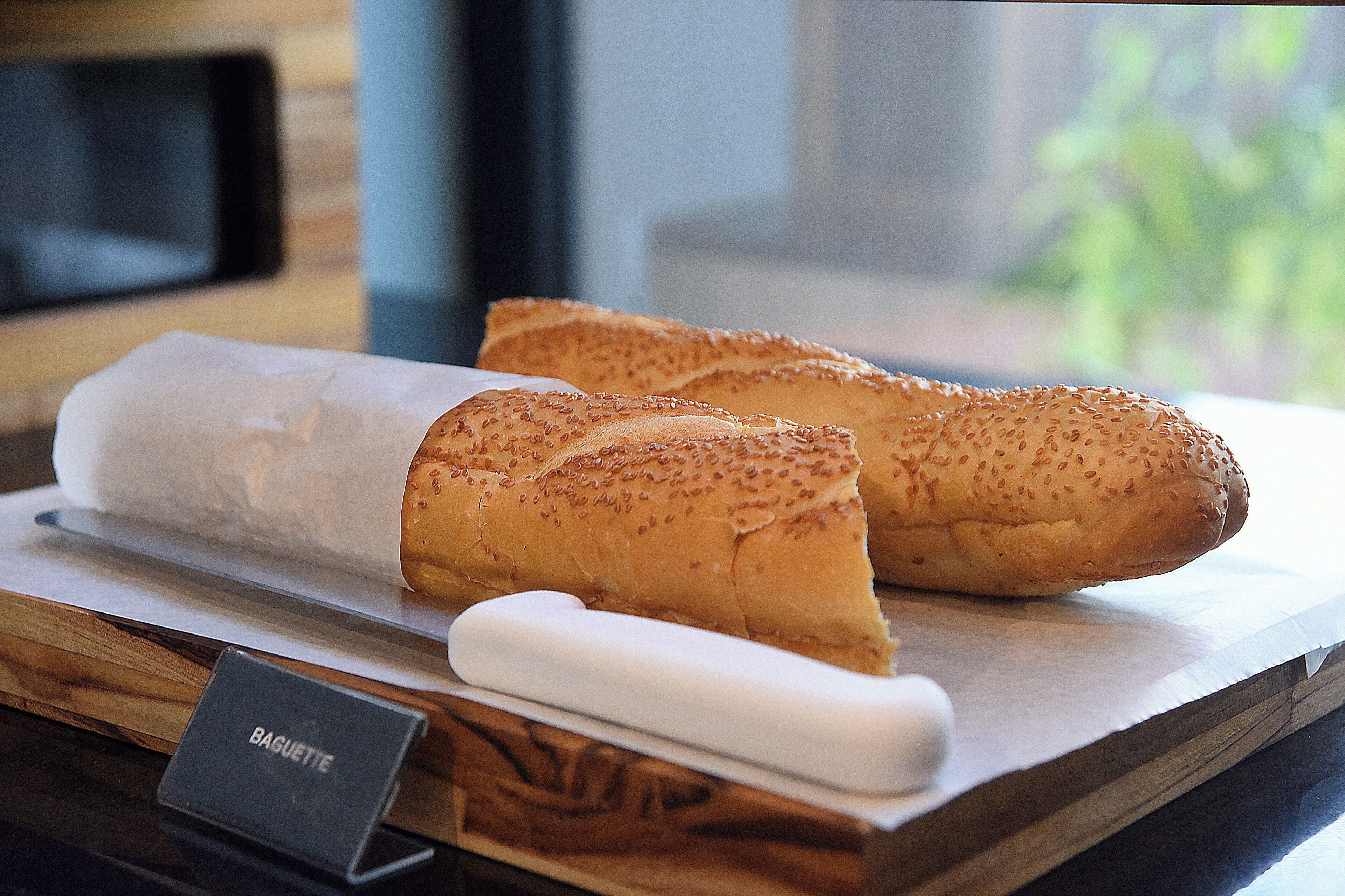 Des baguettes sur une planche à découper en bois, avec une étiquette indiquant « Baguette ».