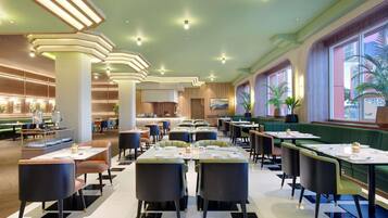 A spacious restaurant with high ceilings, modern lighting, and a view of the outdoors.