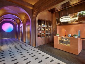 A hotel lobby with a central reception desk, arched ceiling, and a patterned floor.