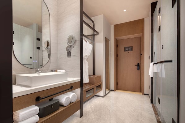 A modern bathroom with a large mirror, a sink, and a shower area. - Novotel Lianyungang Haizhou (Lianyungang)