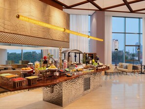 A modern hotel lobby with a buffet area featuring a variety of food items and a seating area with a sofa and chairs. - Novotel New Delhi City Centre (New Delhi)