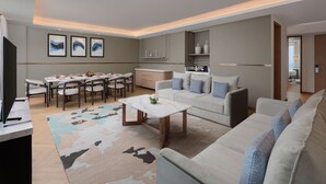 A modern living room with a sofa, coffee table, and dining area. - Novotel New Delhi City Centre (New Delhi)