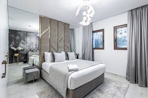 A modern bedroom with a large bed, a mirror, and a view of the outside.