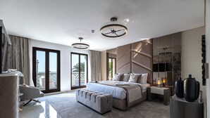 A modern bedroom with a large bed, a seating area, and a balcony. - EDEN'S Homes & Villas - Balqis Residence (Dubai)