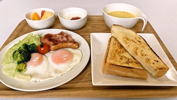 A breakfast tray with toast, eggs, bacon, sausages, and vegetables.