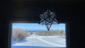 A room with a large window overlooking a snowy landscape. - Amazing Lake Superior view from Ridge Road w/2 car heated garage, pet friendly (Grand Marais)