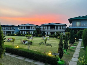 A hotel with multiple buildings, a well-maintained lawn, and a sign indicating a room number.